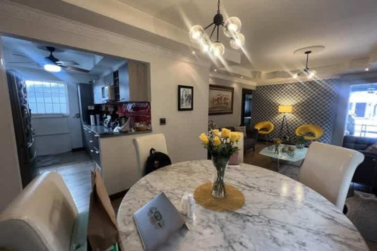 Open concept dining and living area with marble dining table and bright decor at Colinas del Golf Panama