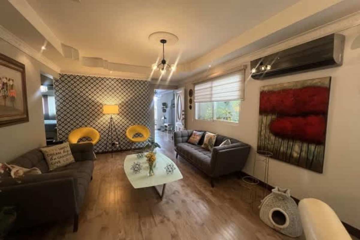 Living area with stone accent wall sectional sofa and large windows Colinas del Golf Panama