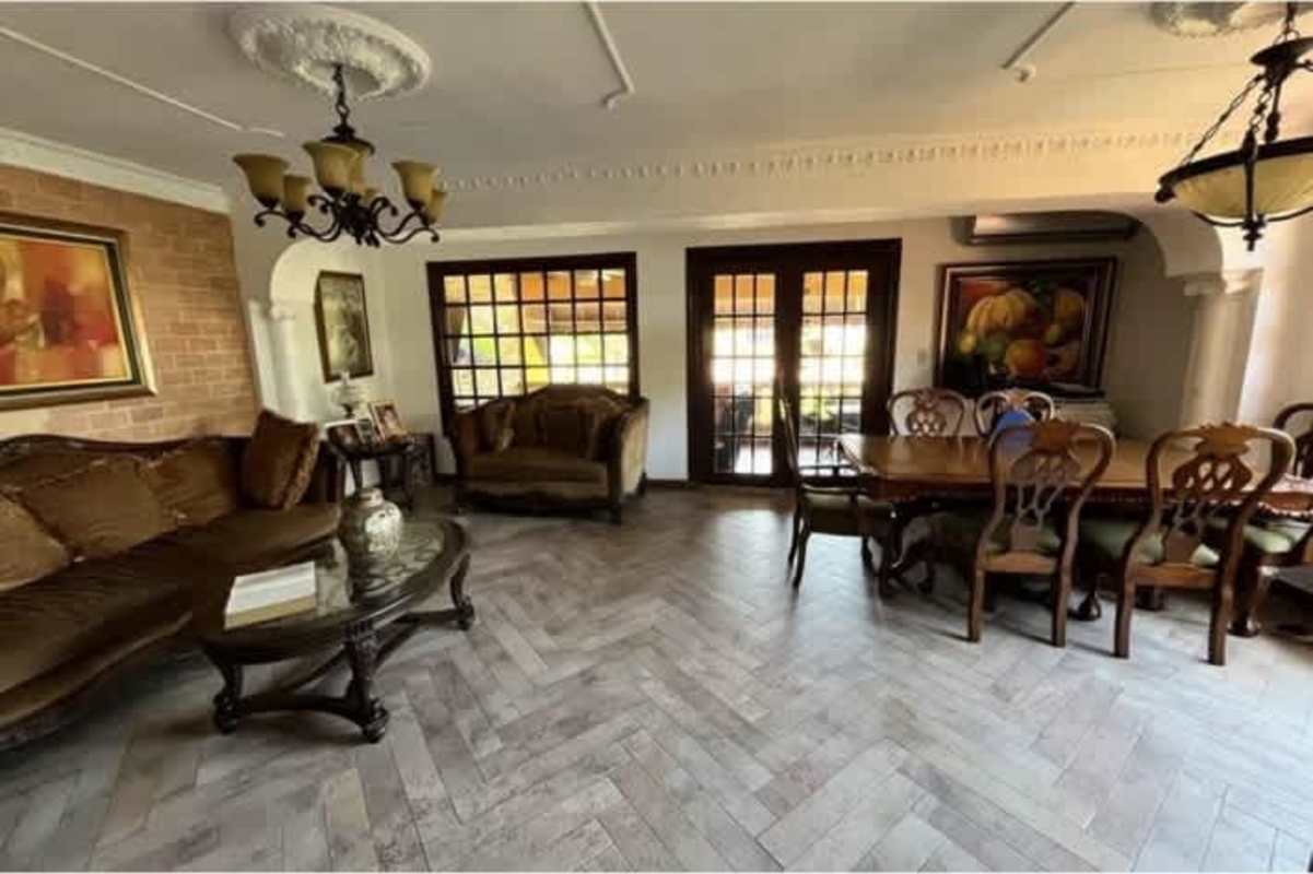 Open living dining area with large windows and wood tile floor in Altos de Panama house