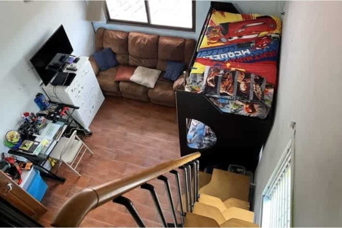 Bedroom with bunk bed, spiral staircase, wooden floor and TV in Altos de Panama house