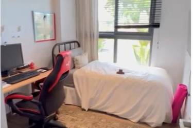 Compact bedroom with workstation, large window, gaming chair in apartment for rent Panama Pacifico