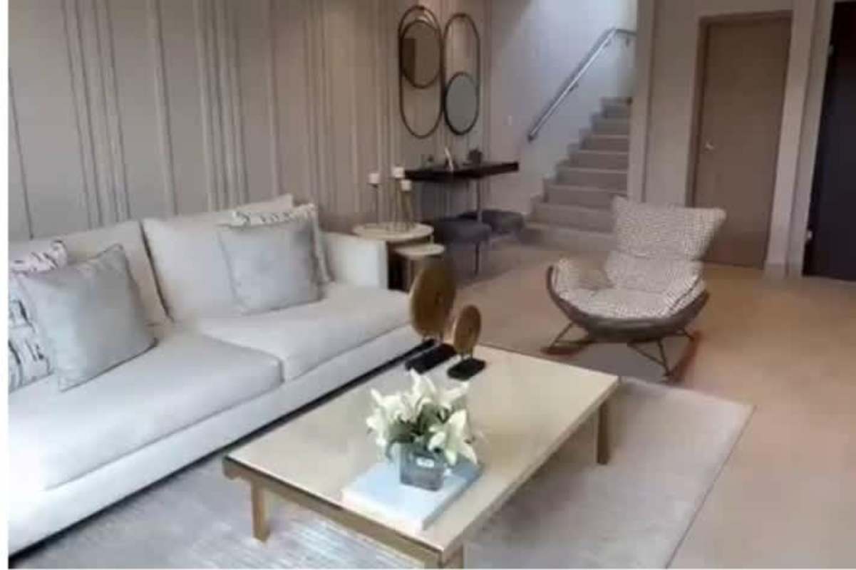 Modern lounge with stairs and light sofa in a two-story house for sale in Costa Sur Panama