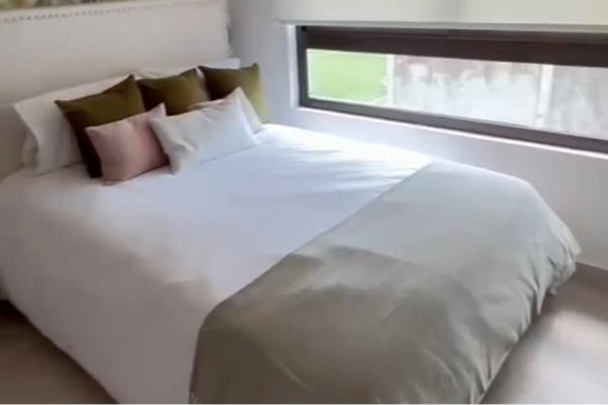 Bright bedroom with large windows and minimalist design in Costa Sur house Panama