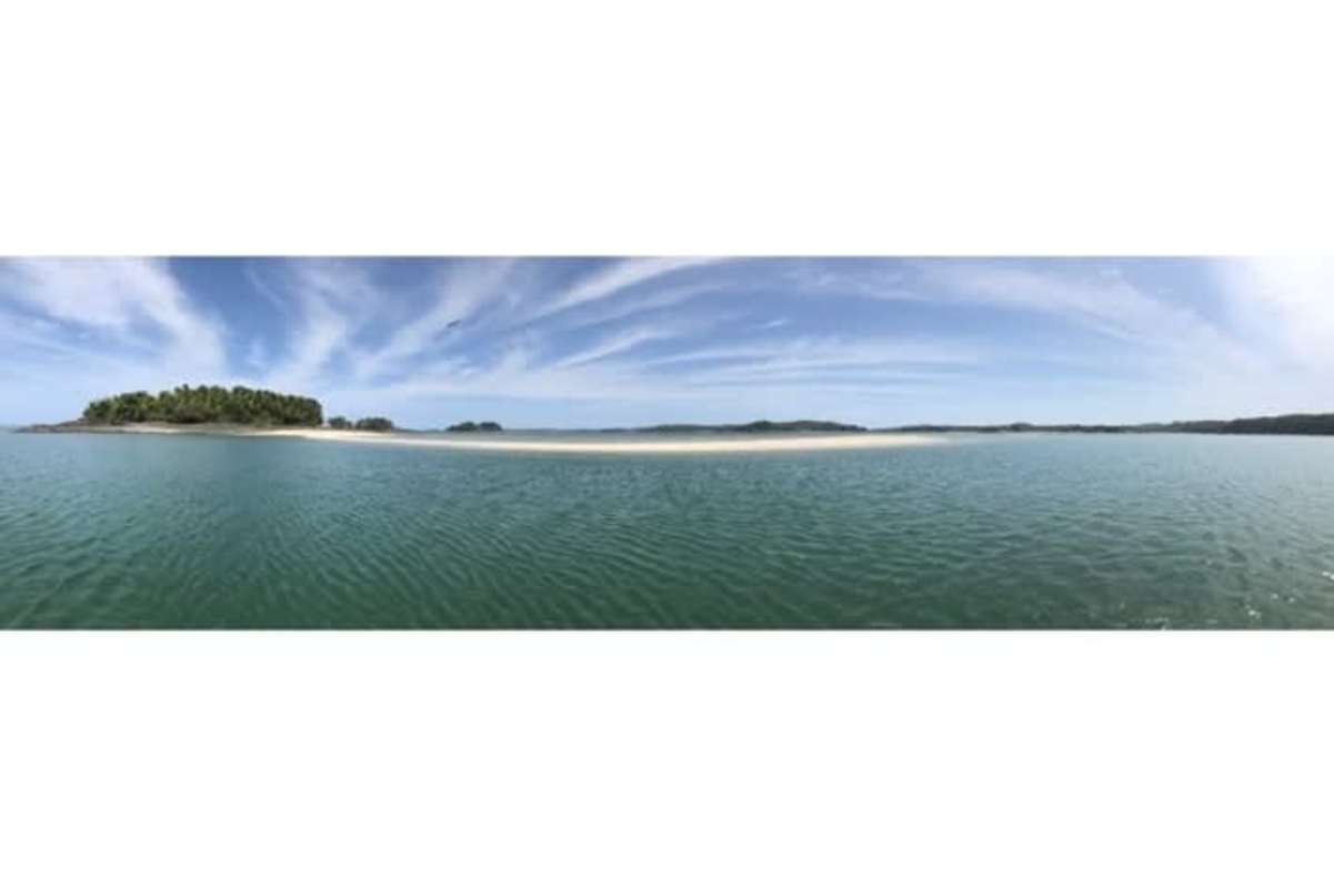 Aerial shot of pristine beachfront and rocky shoreline Isla Quiros