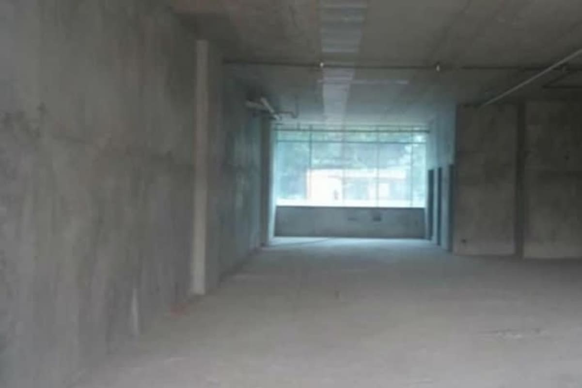 Large empty unfinished commercial unit with concrete walls and large window in Plaza 77 Panama City