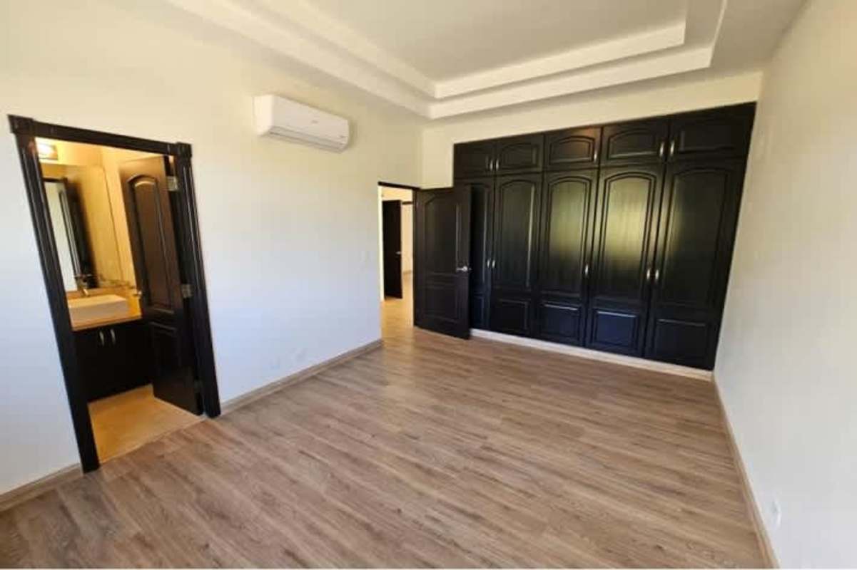 Bedroom with built-in black closet and wood floors in luxury house Antigua Costa del Este Panama