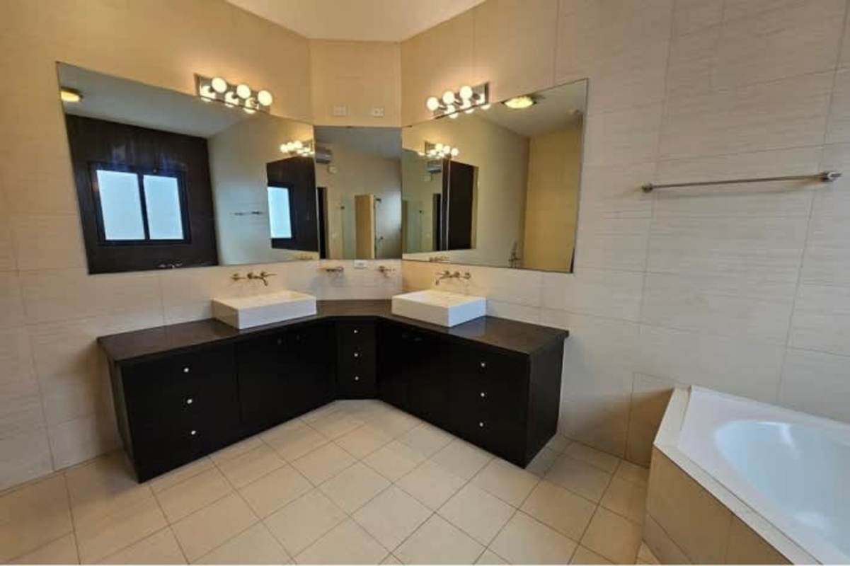 Contemporary double sink bathroom with bathtub, glass shower, large mirrors in Antigua Costa del Este Panama