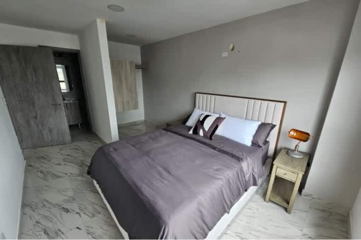 Stylish bedroom with marble floor, gray accents, and large windows at The Gray Tower Panama City