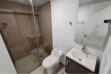 New apartment bathroom with glass shower enclosure, vanity in historic district Panama City