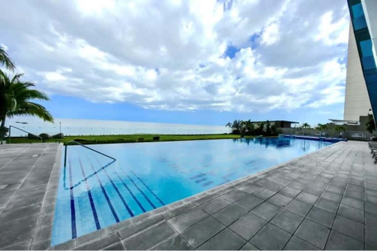 Spacious modern living room with terrace and floor-to-ceiling windows with city and ocean views at Grand Tower Panama