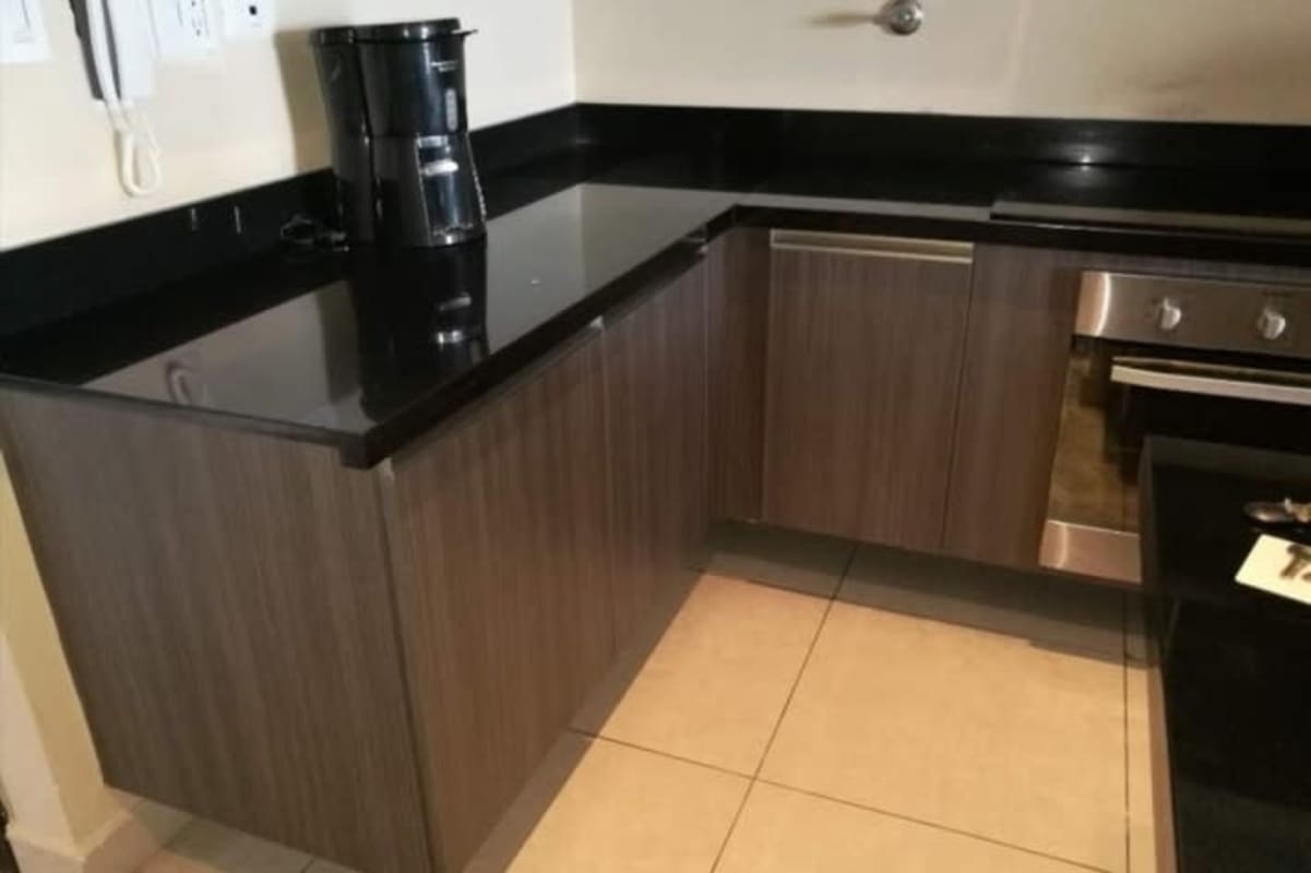 Stylish kitchen with wood cabinets, granite countertops BICSA Financial Center Apartment