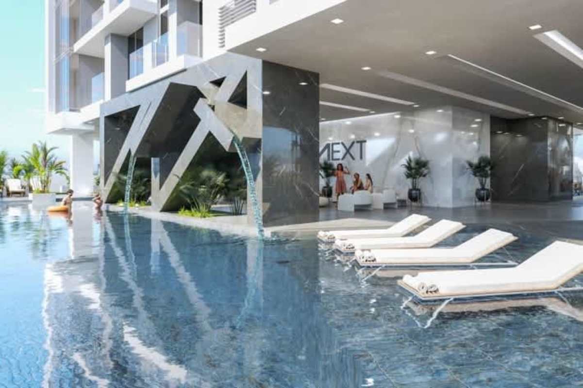 Infinity pool with waterfall feature and sun loungers at PH Next luxury condos Panama City