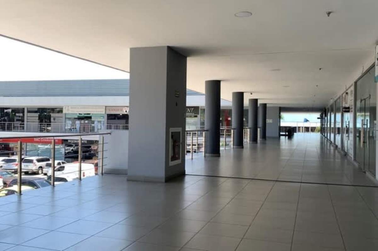 Commercial shopping center with glass storefronts and large parking area Centennial Plaza Panama