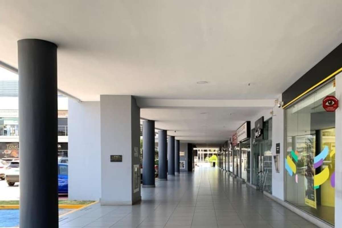 Covered walkway with glass storefronts at Centennial Plaza San Miguelito Panama