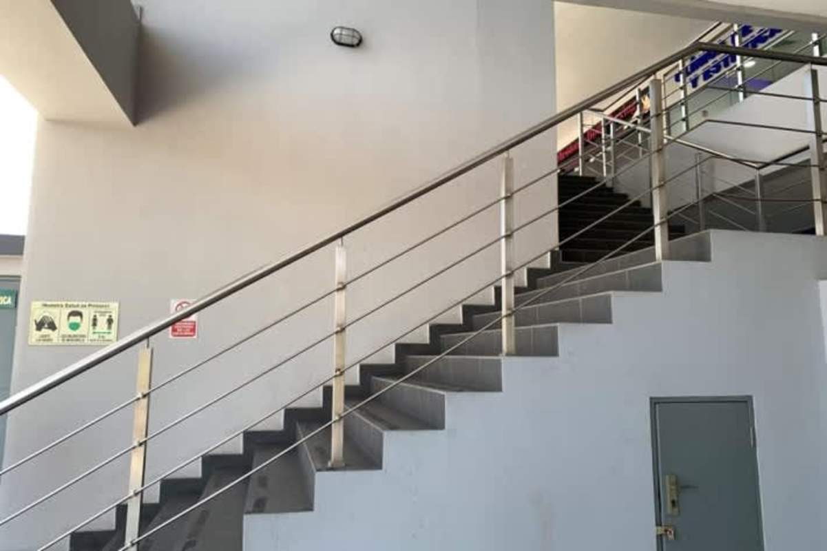 Stairwell with tiled steps and stainless handrail inside commercial plaza San Miguelito Panama