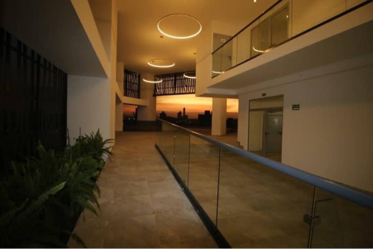 Spacious lobby hallway with glass railings and city sunset view PH La Loma Tower Panama