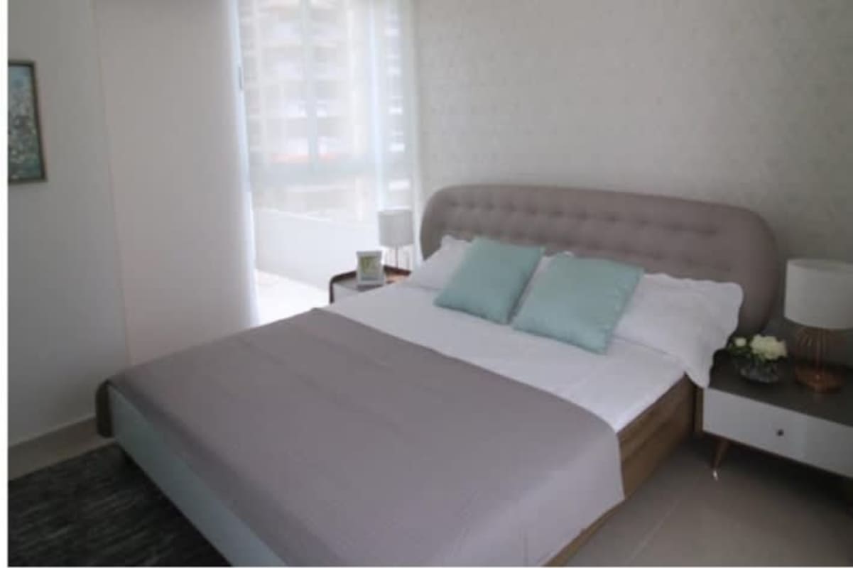 Master bedroom with upholstered bed, floor-to-ceiling window, city views PH La Loma Tower Panama City