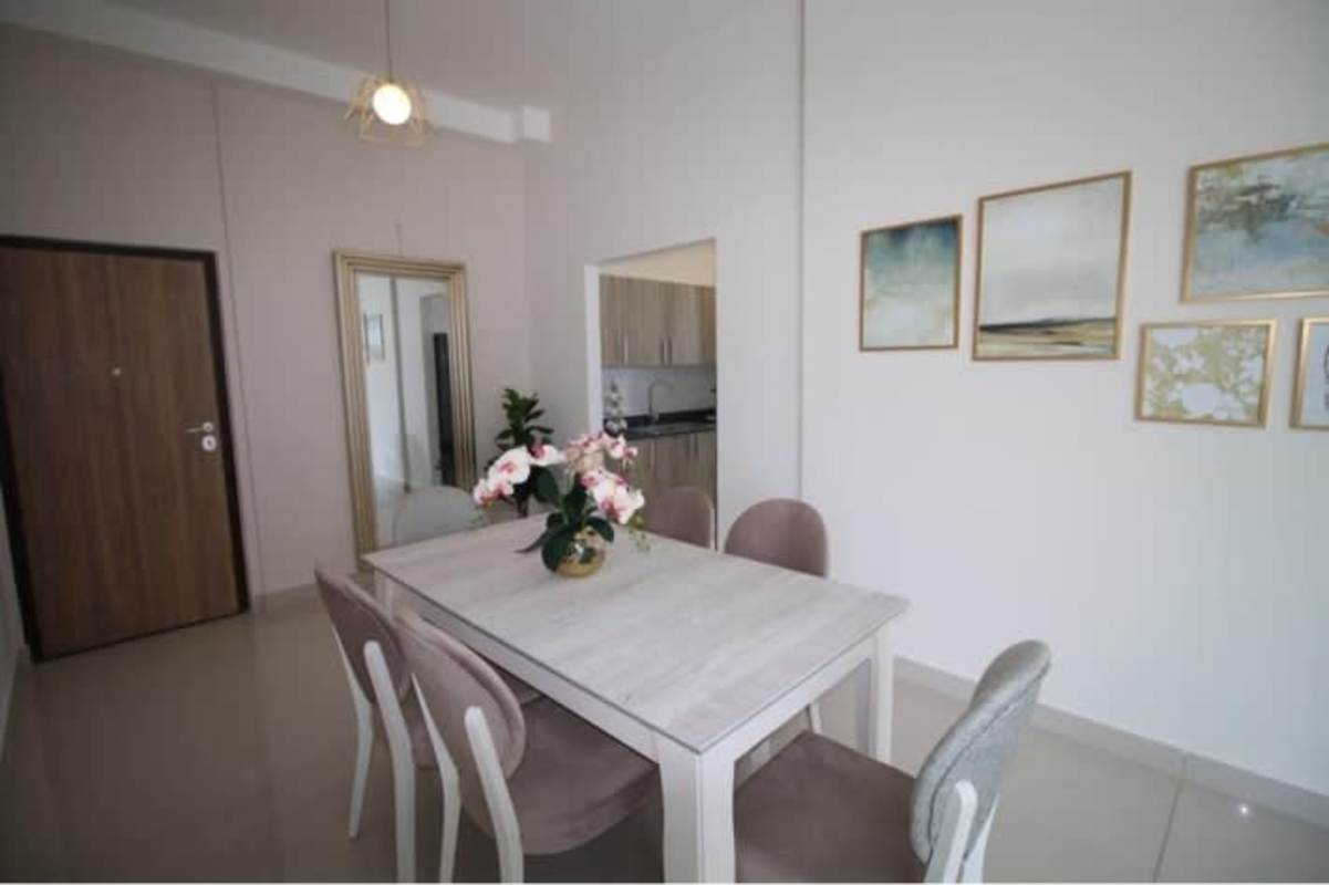 Contemporary dining room with mirror, pendant light, 6 chairs, open to kitchen PH La Loma Tower Panama City