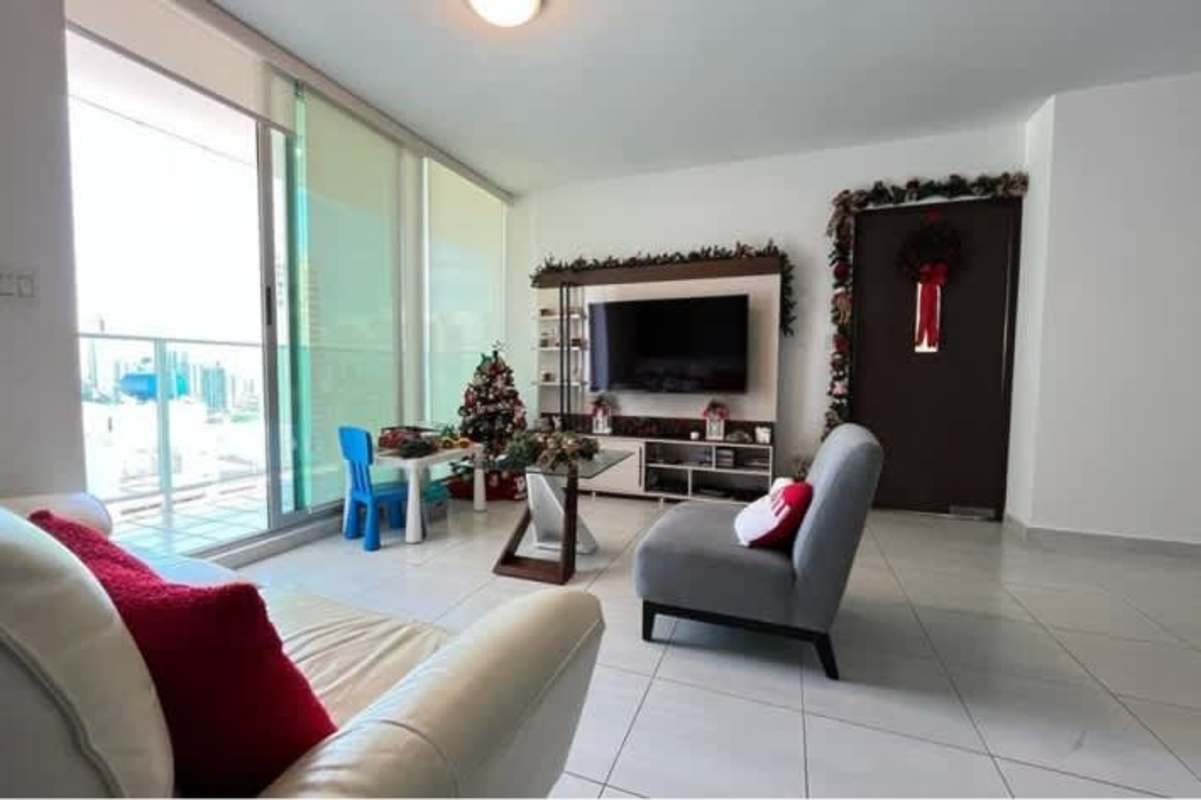 Open living and dining room with Christmas decorations and large windows in Panama apartment