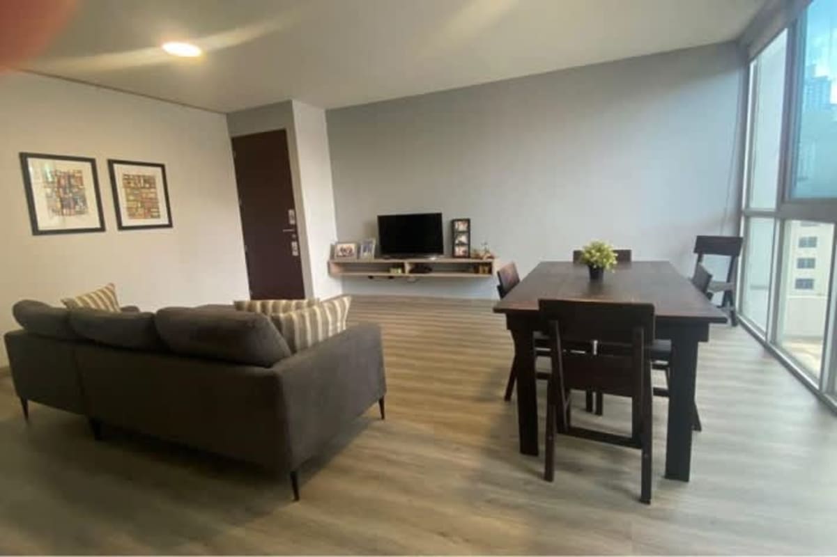 Spacious community room with wood floor, wall mirror, large windows at PH Sky Blue Tower Panama City