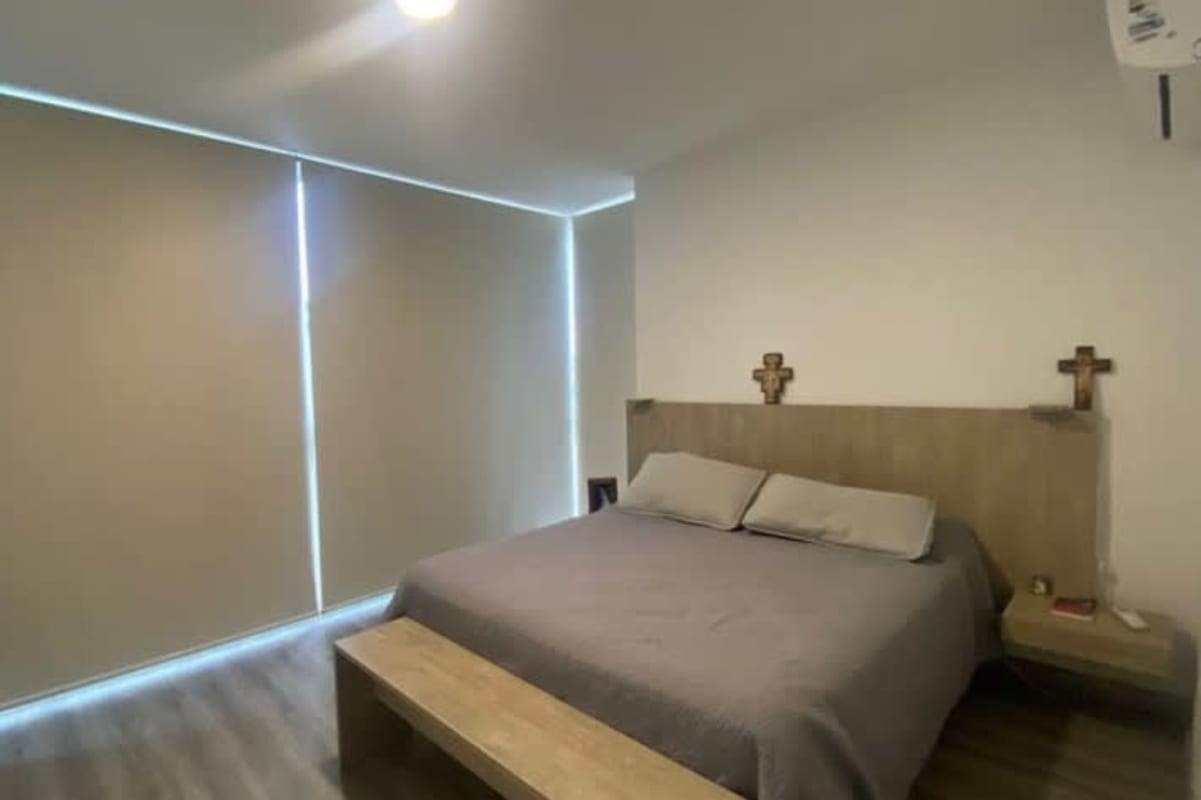 Minimalist bedroom with large window, wood floors and natural light at PH Sky Blue Tower Panama