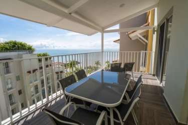 Dining table on covered balcony with ocean views in PH Puntarena Buenaventura apartment
