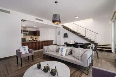 Spacious living room with glass wall ocean views in luxury apartment Buenaventura Panama