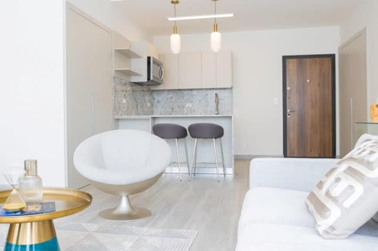 Modern living room corner with chaise lounge, floor lamp, wood accent wall at PH Skypark Costa del Este