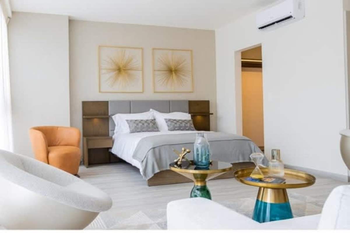 Spacious stylish bedroom with accent chairs and artwork PH Skypark Costa del Este Panama