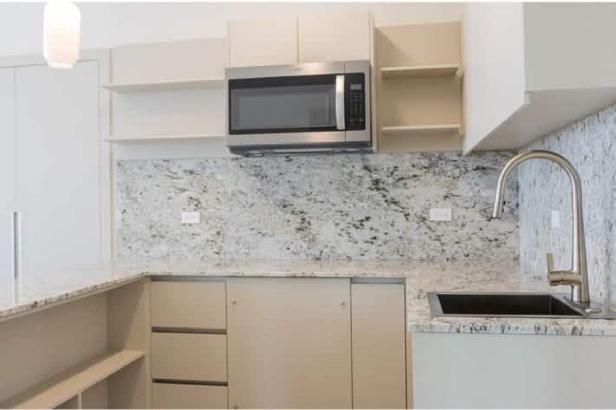 Modern kitchen with granite countertops, built-in microwave, and faucets in PH Skypark Panama City