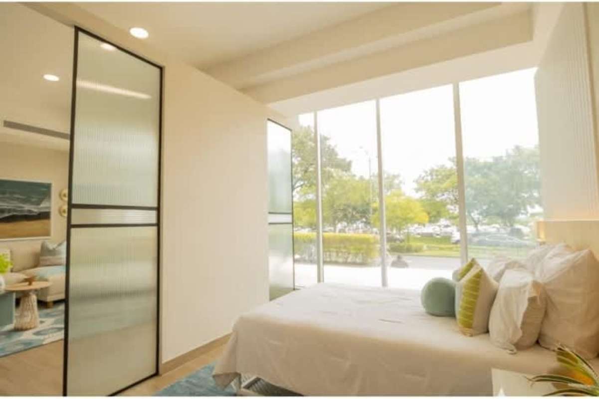 Bright bedroom with floor-to-ceiling glass partitions and garden view in Sky Balboa Tower
