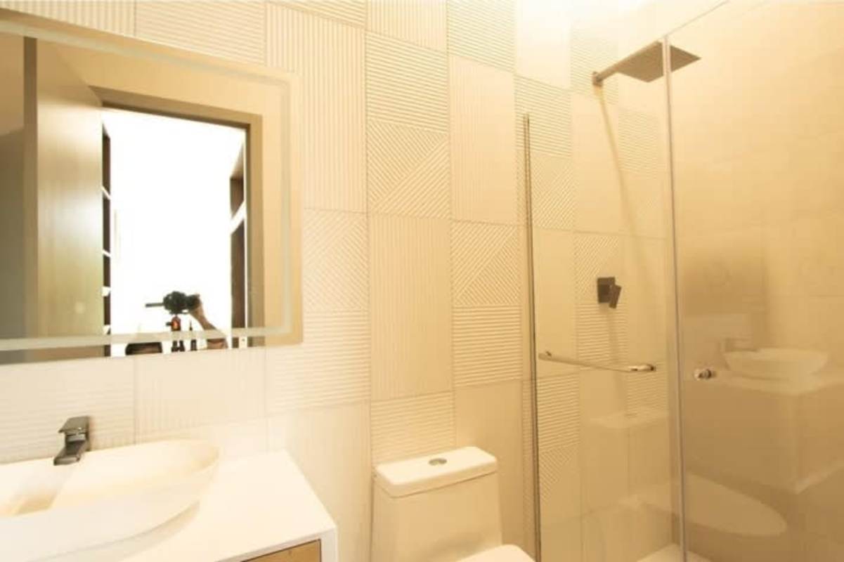 Modern bathroom with glass-enclosed shower, textured tiles, and designer fixtures in Sky Balboa Tower