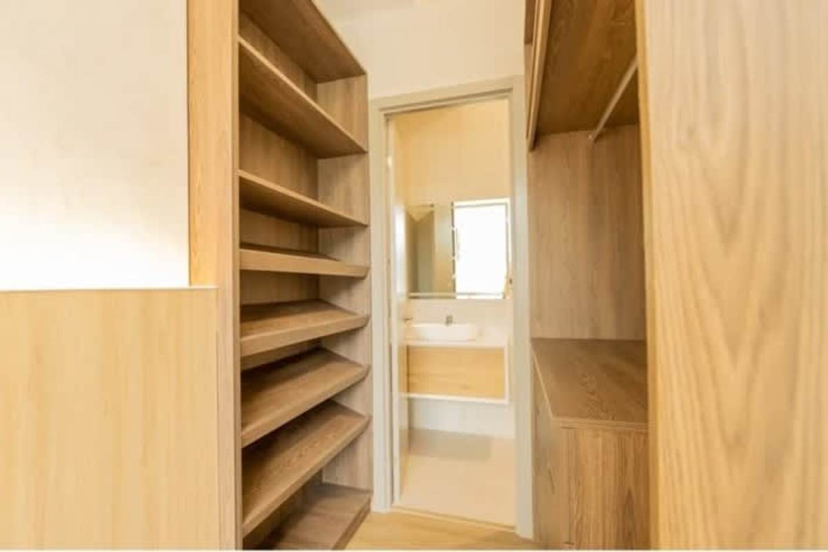 Wood shelving walk-in closet connecting to modern bathroom in Sky Balboa Tower Panama