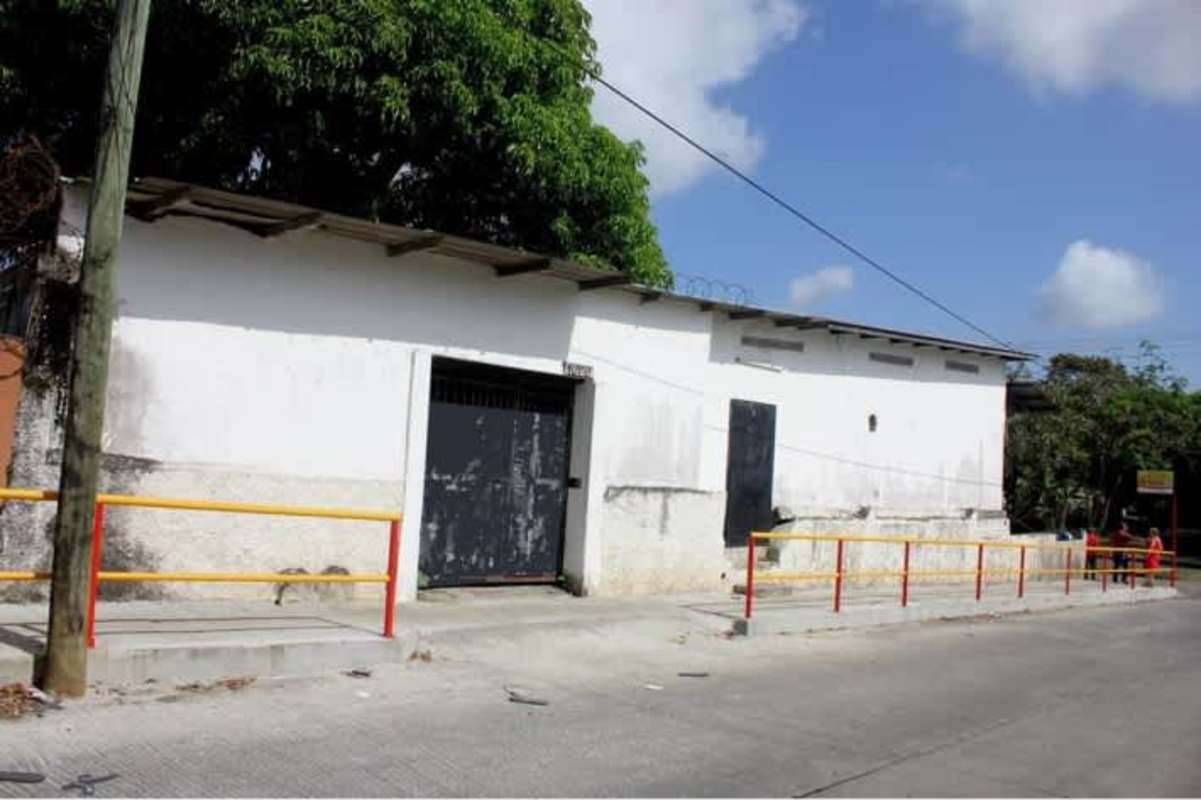 Commercial warehouse exterior with concrete walls and security fencing corner lot Panama City