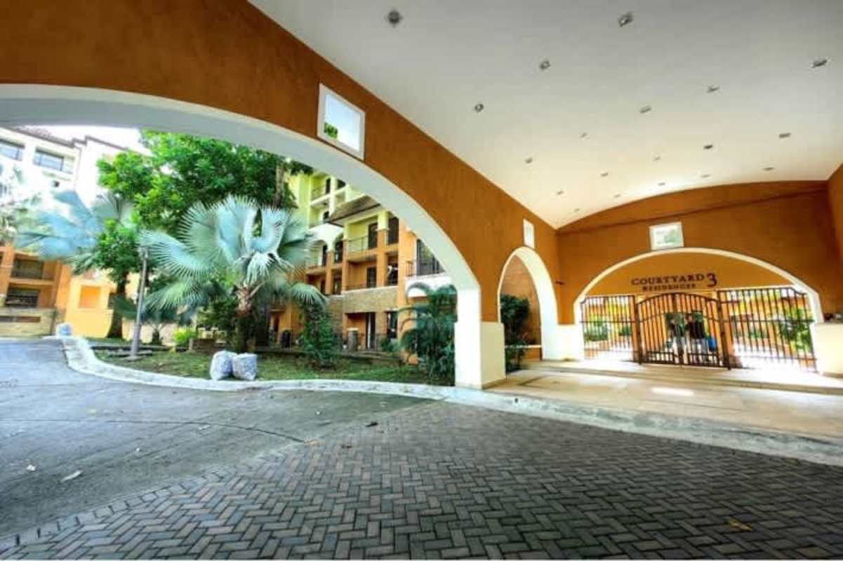 Secure gated entry arch with lush greenery Embassy Club PH Courtyard Clayton Panama