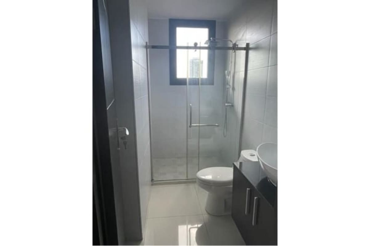 Modern bathroom with glass shower enclosure, toilet and vanity at PH El Cangrejo Panama