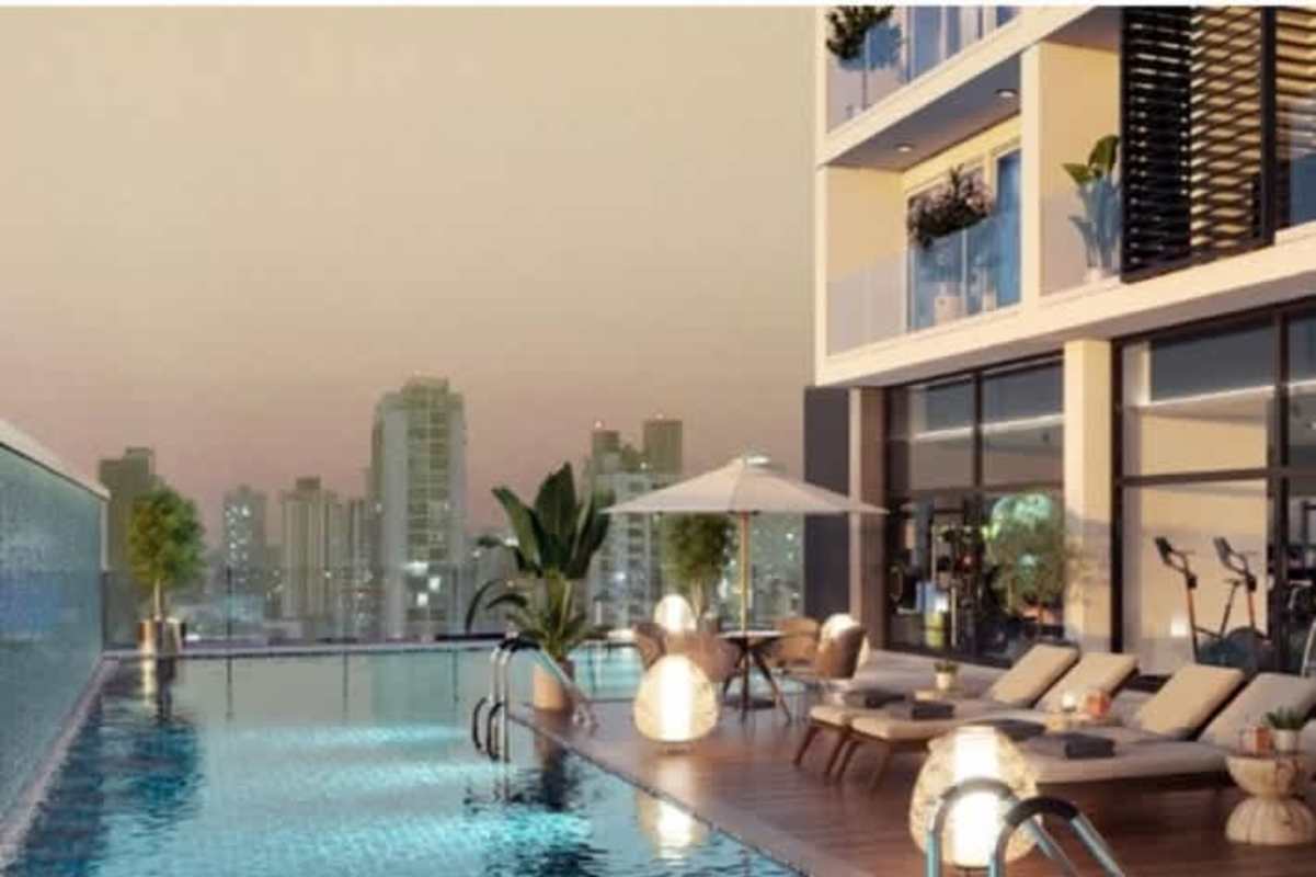 Luxurious outdoor pool area with loungers and skyline backdrop at PH Smart Suites Panama City