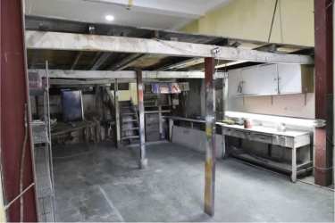 Open commercial space with concrete floor, storage shelving, and mezzanine near Casco Viejo Panama City