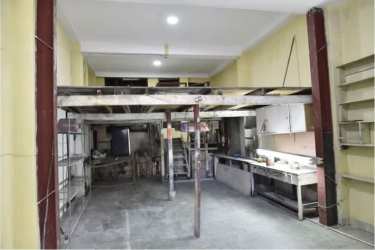 Industrial style interior with metal beams, shelving, mezzanine and fluorescent lights in Panama commercial property