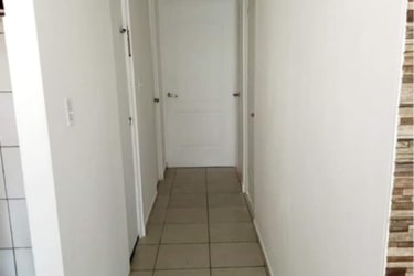 Clean ceramic tile hallway with accent wall inside house Verde Real La Chorrera