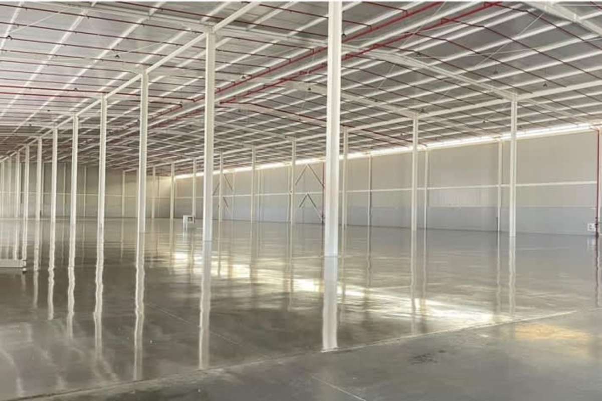 Interior view of industrial warehouse with metal roofing, open plan designed for distribution hub