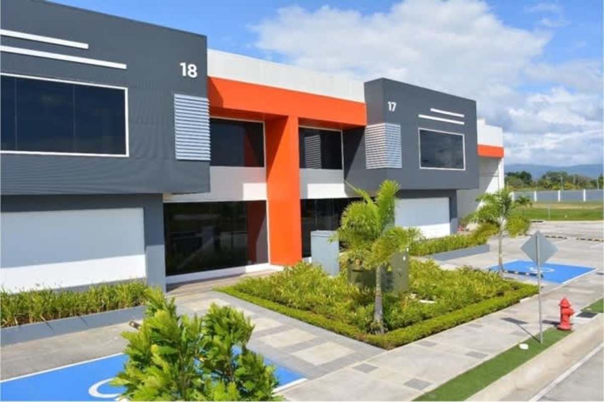 Vibrant facade with glass paneling, unit numbers, landscaping of warehouse park Panama