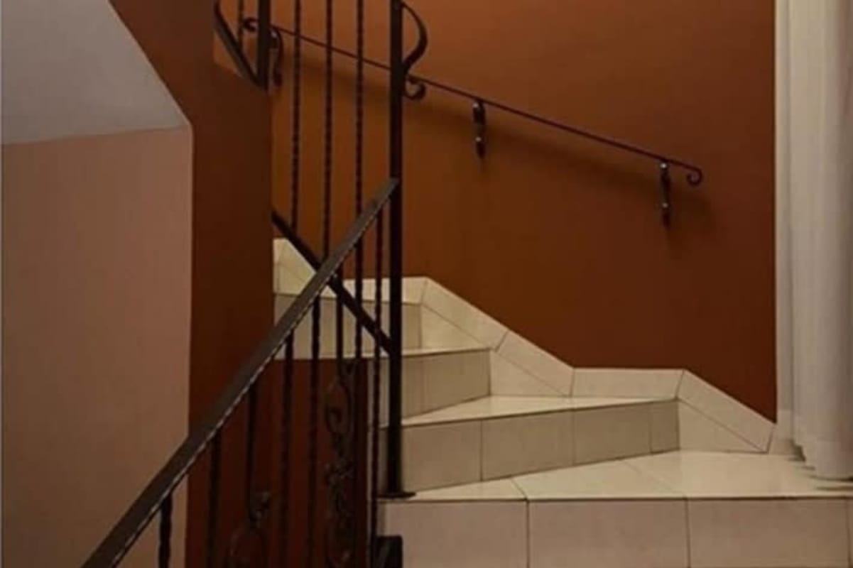 Tiled staircase with decorative iron railing inside Dorado Lakes family house Panama