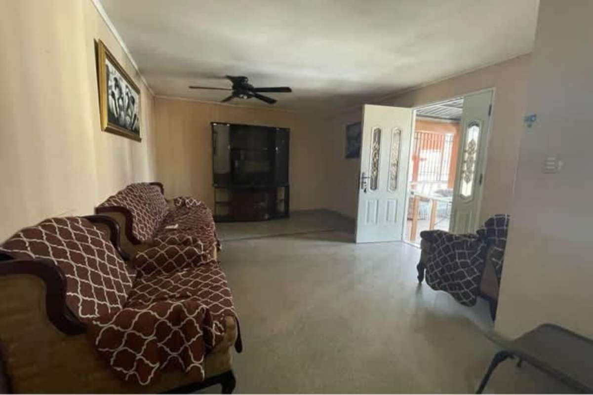 Living area with sofa set, ceiling fan, beige walls in Villa Lucre near Metro Panama