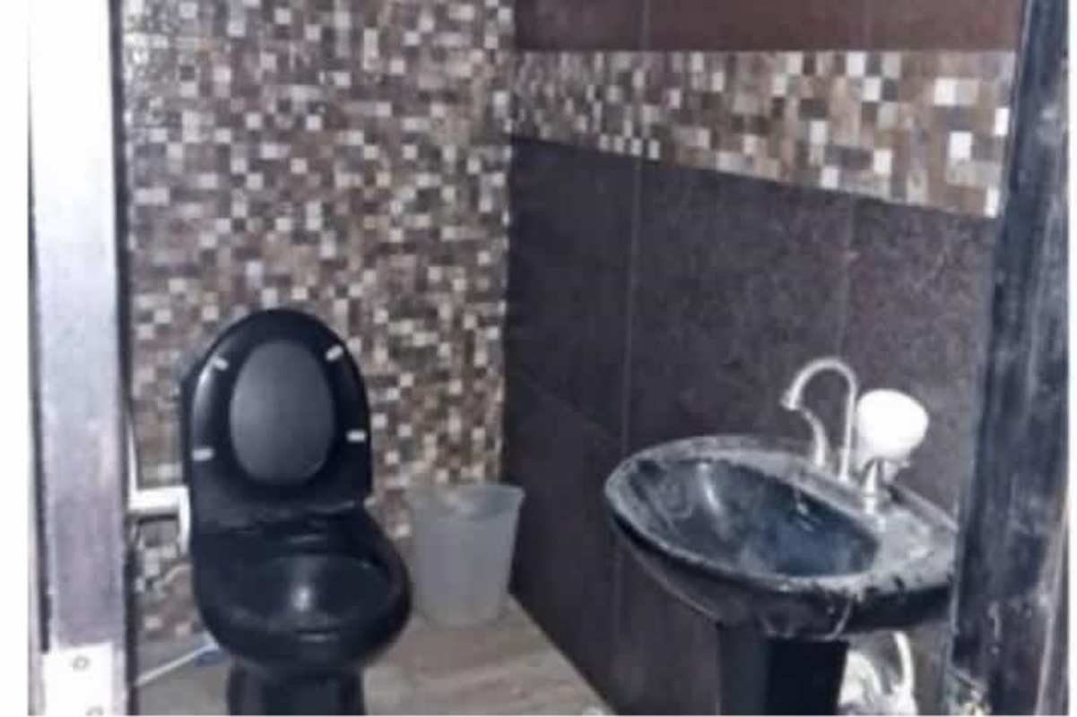 Stylish bathroom with black toilet and pedestal sink in commercial space Panama City