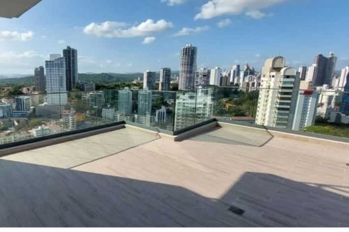 Spacious kitchen with large window, granite countertops, and wood cabinetry in luxury apartment Panama City