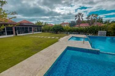 Private swimming pool surrounded by tropical garden and patio in Decameron Golf Villas Panama