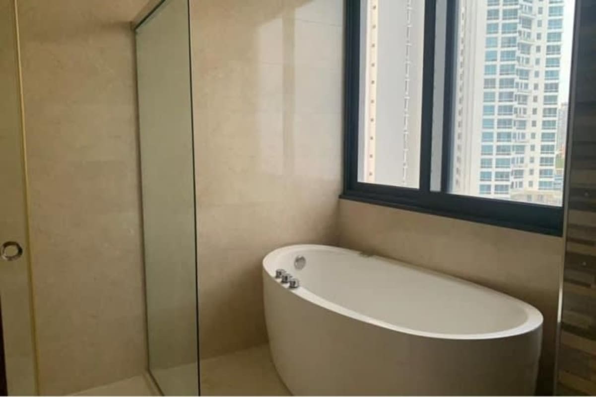 Modern bathroom with glass shower and bathtub overlooking city in PH Oceania Costa del Este Panama