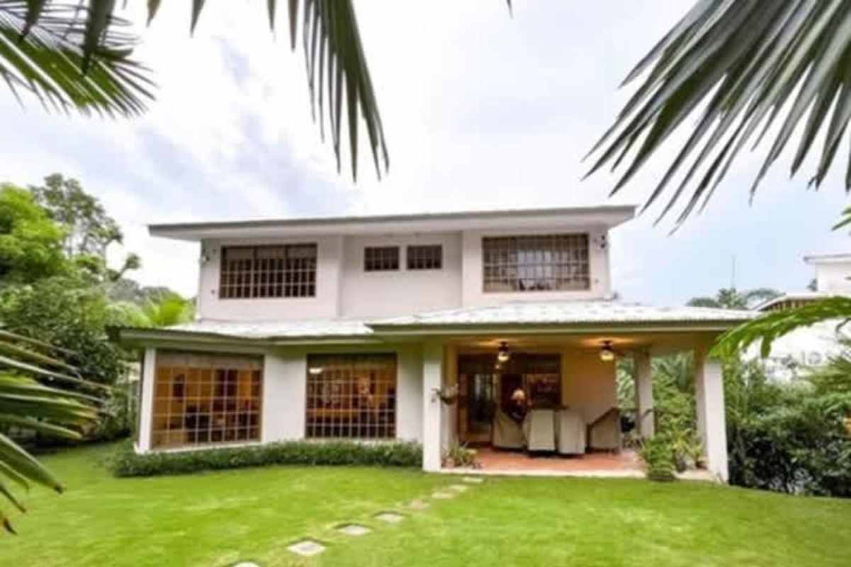 Modern kitchen with center island, granite countertops, wood cabinetry at Cardenas Village home Clayton Panama