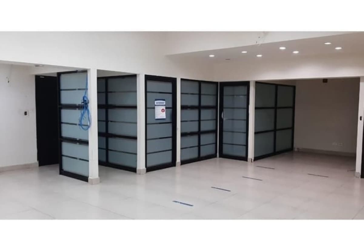 Large open-plan office with glass partitions and minimalist design at PH El Cangrejo Business Center